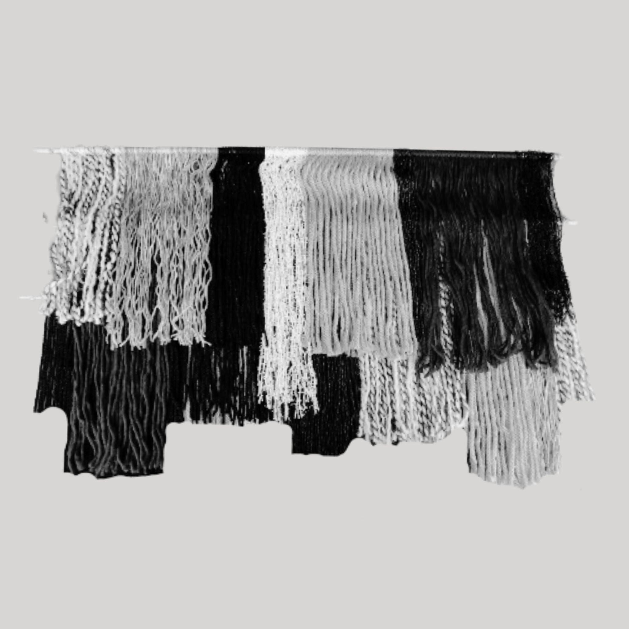 black white and gray tiered yarn wall hanging