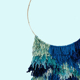 blue yarn on a metal hoop wall hanging